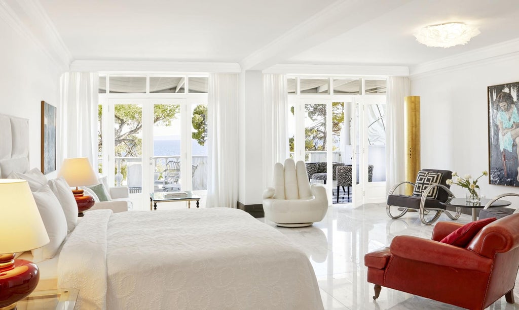 Luxurious Panorama Sea View Suite at Greek coastal resort, featuring elegant white interiors, expansive blue Aegean Sea vista, and private balcony with modern design