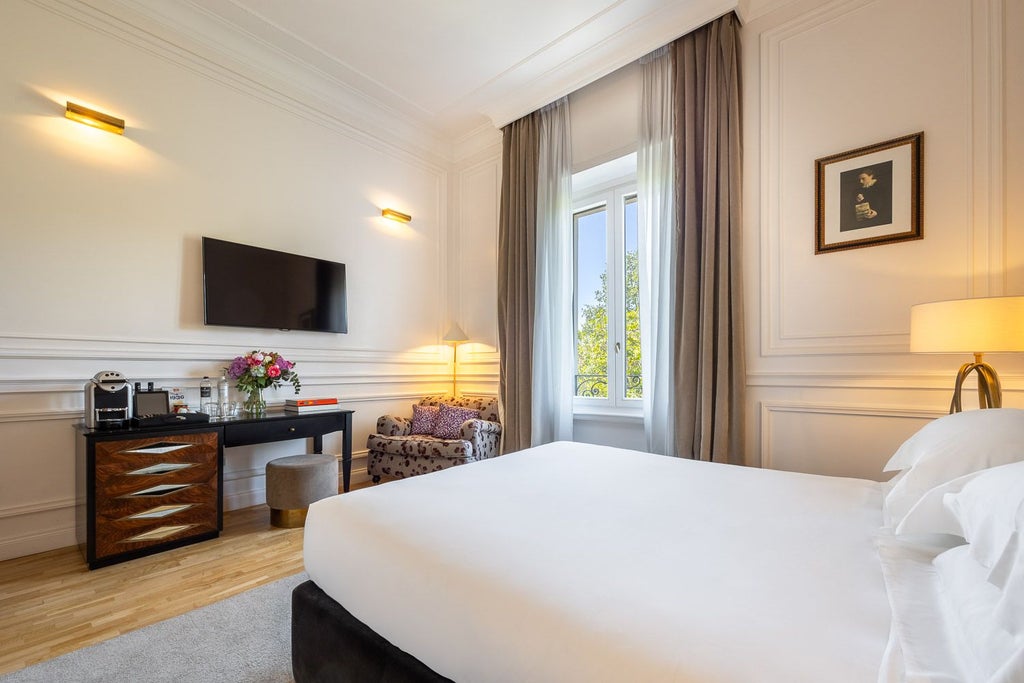 Elegant double deluxe hotel room at Palazzo Dama, featuring crisp white linens, designer furnishings, and sophisticated Italian interior with soft neutral tones.