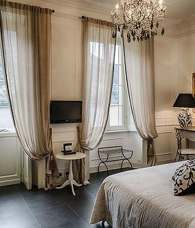 Elegant Italian lakeside suite with plush white bed, ornate wooden furnishings, large windows overlooking scenic landscape at Relais Villa Vittoria