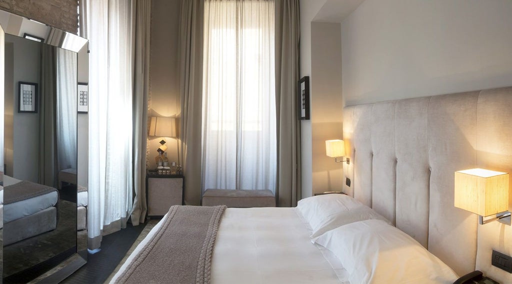 Elegant junior suite with refined Italian design, featuring plush white bedding, minimalist decor, and soft natural lighting in a luxurious boutique hotel setting