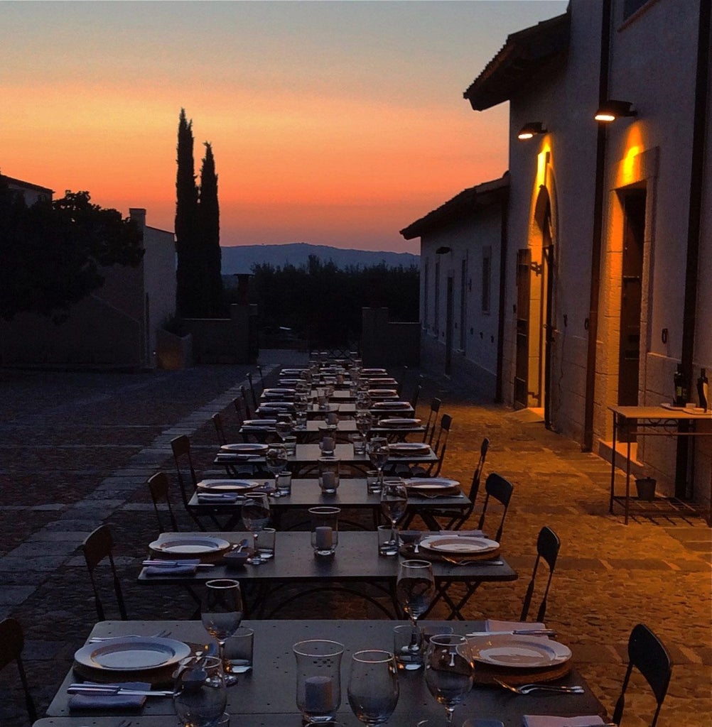 Elegant stone farmhouse at sunset, golden Sicilian landscape, rustic olive grove surrounding luxurious boutique hotel with traditional Mediterranean architecture