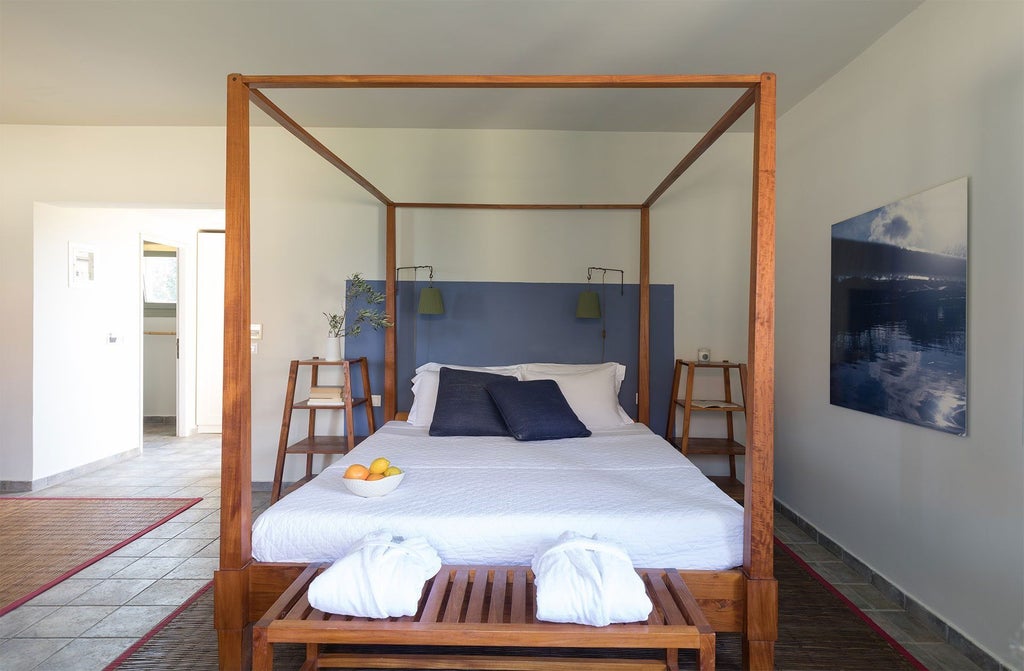 Elegant Honeymoon Suite at Emelisse Resort, featuring white minimalist decor, crisp linens, and panoramic Grecian sea view through large windows