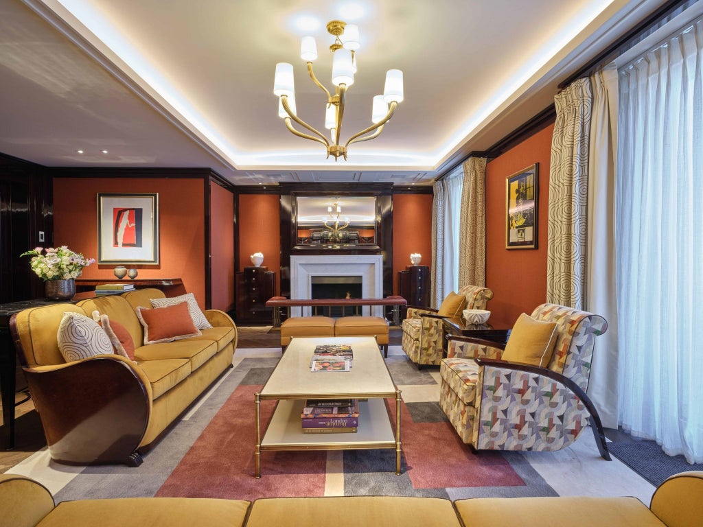 Luxurious Art Deco-inspired Roosevelt Suite at Beaumont Hotel, featuring plush golden furnishings, rich mahogany details, and elegant geometric patterns in Mayfair, London