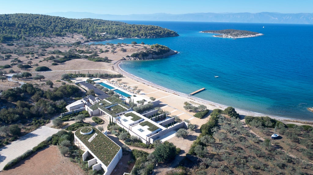 Luxury infinity pool overlooks Mediterranean Sea at sunset, white columns and pavilions reflect Grecian architecture at Amanzoe resort