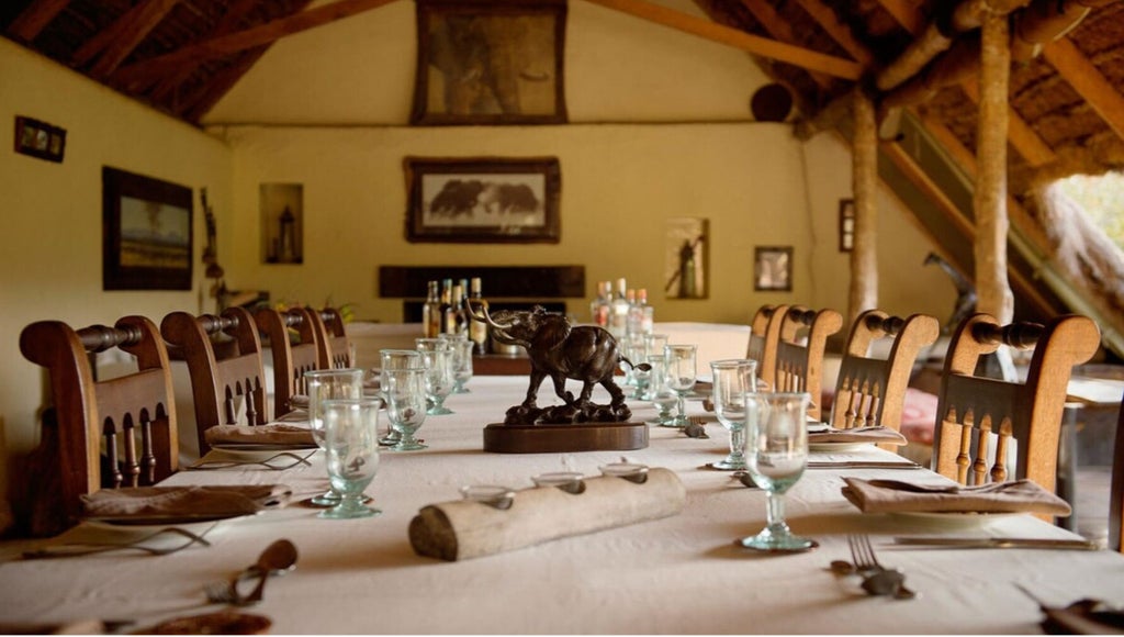 Luxurious safari tent nestled among acacia trees in Kenya's wilderness, with elevated wooden deck offering panoramic savanna views