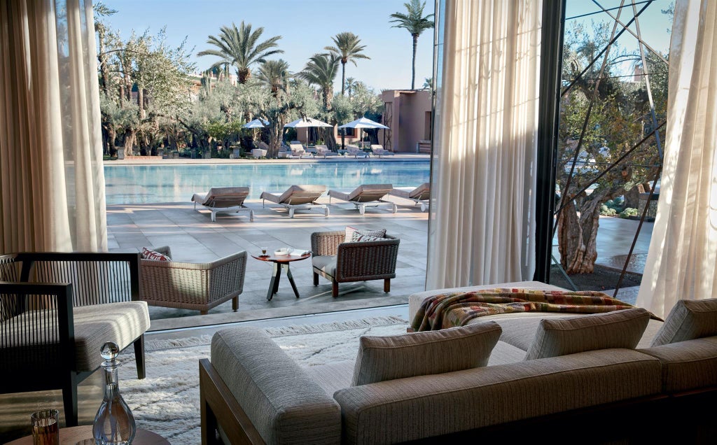 Elegant Moroccan hotel exterior featuring white Art Deco architecture, grand entrance with ornate details, and palm-lined driveway