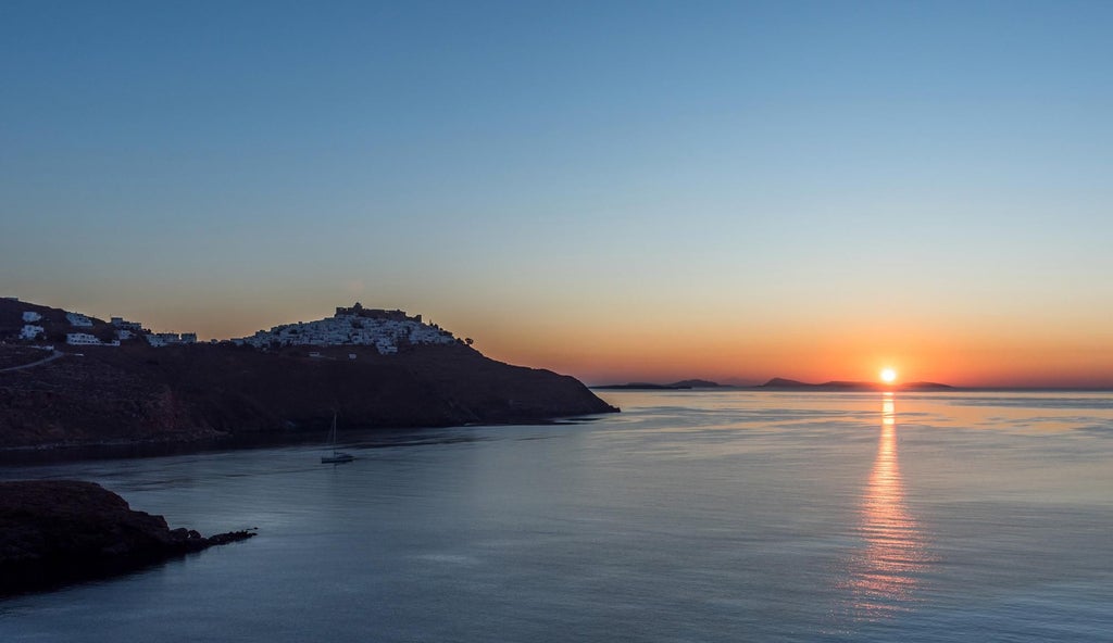 Elegant white-washed Greek suites overlooking Aegean Sea, traditional Cycladic architecture with blue-trimmed balconies and stunning panoramic coastal landscape