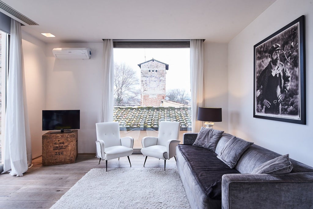 Elegant Italian loft suite with minimalist design, exposed wooden beams, contemporary furnishings, and soft natural light streaming through large windows.