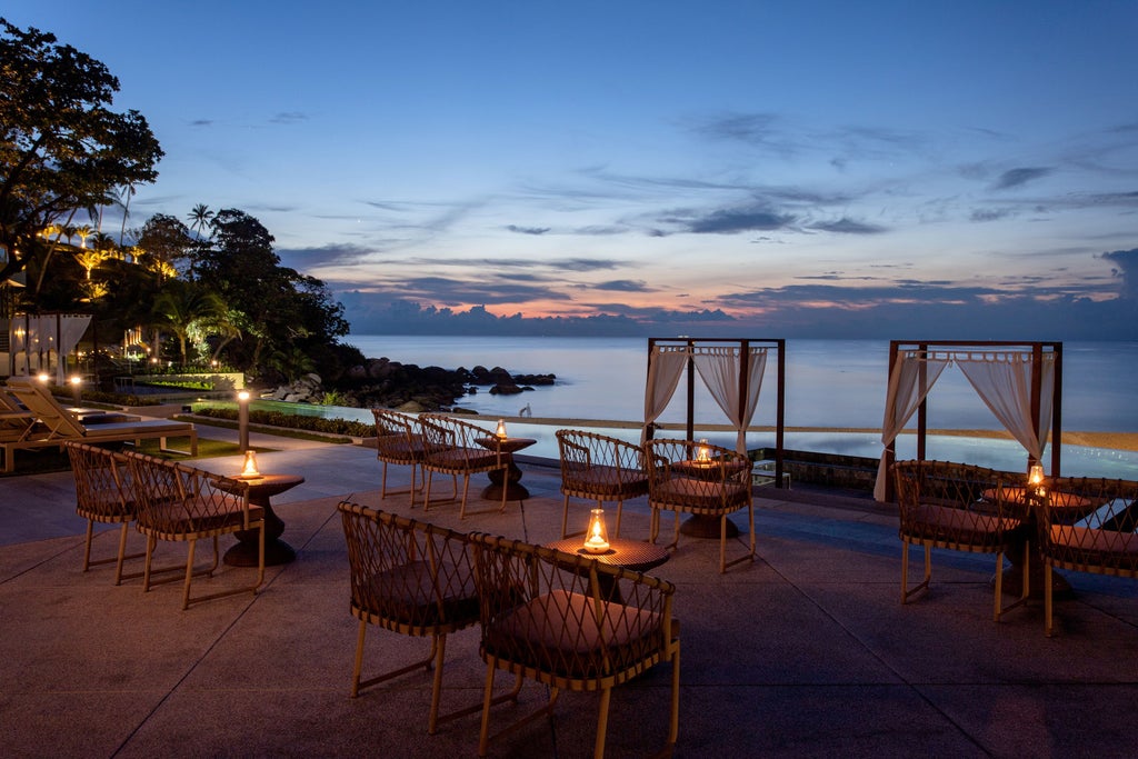 Luxury beachfront resort with infinity pool overlooking Kata Noi Beach, featuring modern villas nestled among tropical palm trees