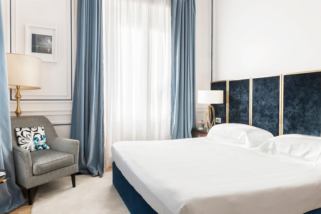 Elegant double deluxe hotel room at Palazzo Dama with plush white bedding, modern Italian design, and soft neutral tones creating a luxurious sanctuary.