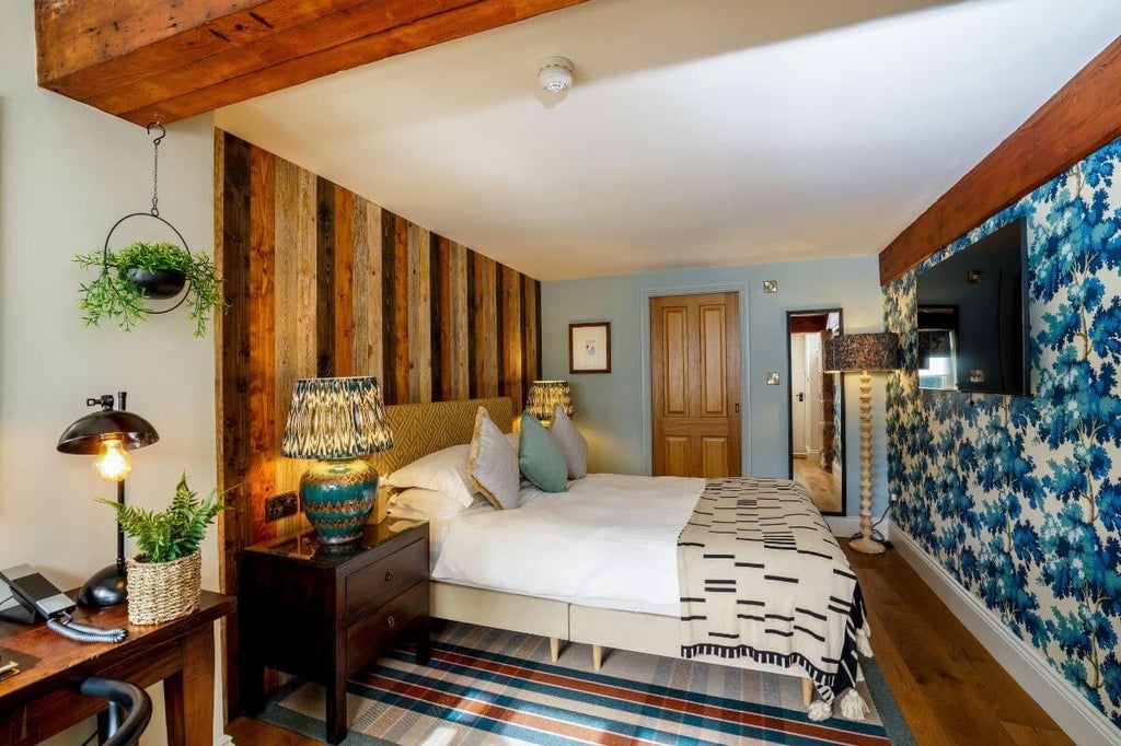 Elegant superior hotel room at the Pheasant Inn with plush bedding, classic wooden furnishings, warm neutral tones, and countryside-inspired sophisticated decor