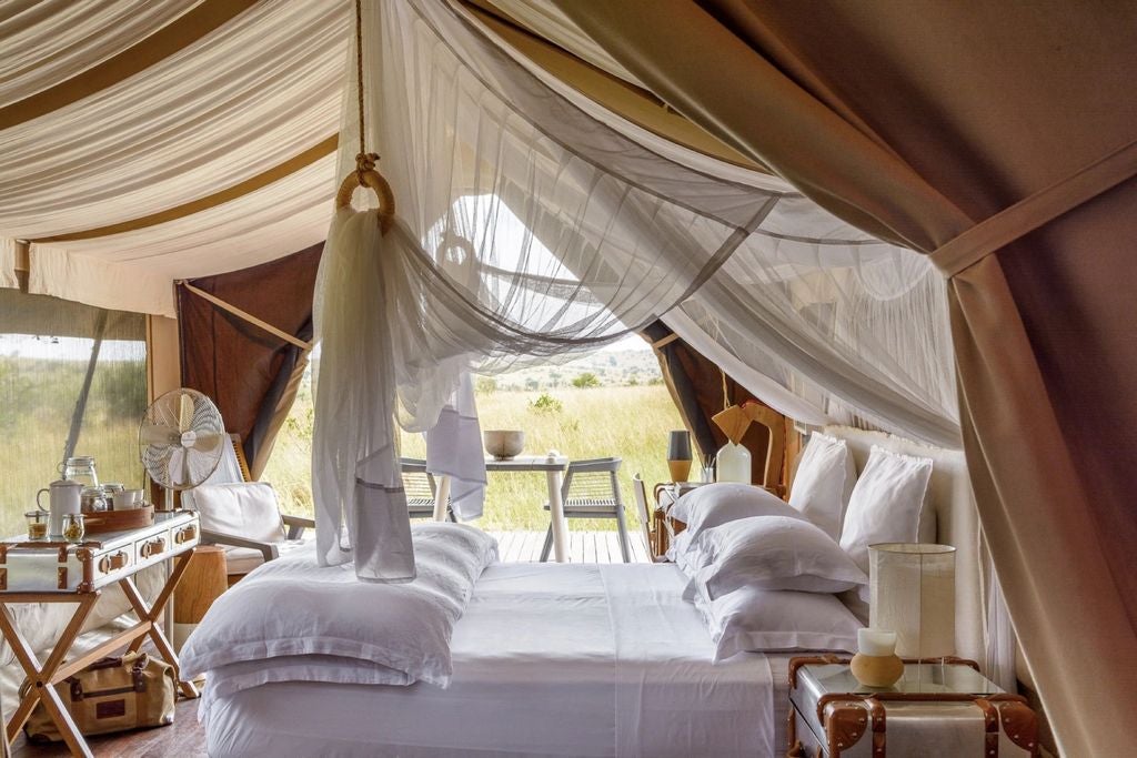 Luxurious safari tent with private deck overlooking the Serengeti plains, featuring contemporary furnishings and canvas walls