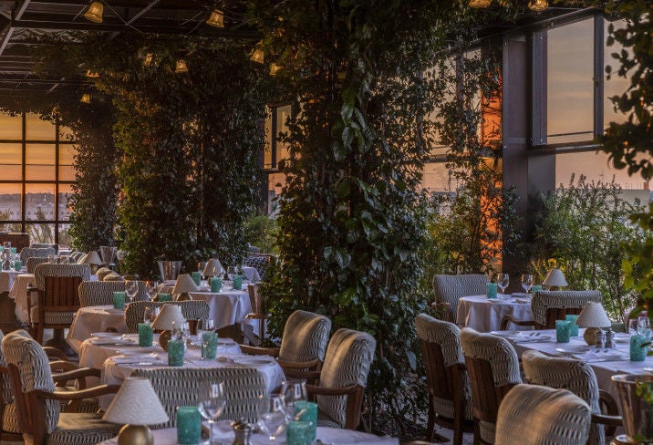 Opulent Italian boutique hotel exterior with ivy-covered walls, classic Roman architecture, and elegant arched windows at sunset