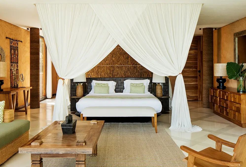 Luxurious beachfront villa with traditional Indonesian design, expansive wooden deck overlooking pristine turquoise waters of Putri Wamoro Beach at NIHI Sumba resort