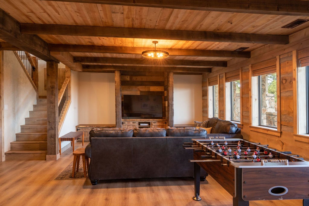 Rustic lodge room with wooden furnishings, plush bedding, and large windows overlooking scenic mountain landscape at Scenset Mountain Ranch accommodation