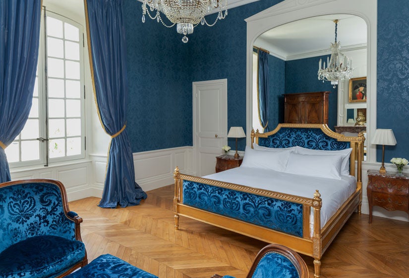 Elegant king room in 18th century château featuring ornate period furniture, crystal chandelier and panoramic French countryside views