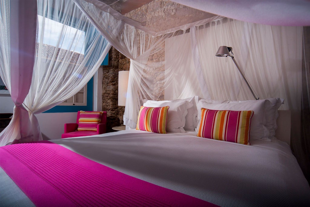 Elegant pink-themed luxury suite with plush bedding, tropical Brazilian decor, and chic turquoise accents in a sophisticated boutique hotel room setting