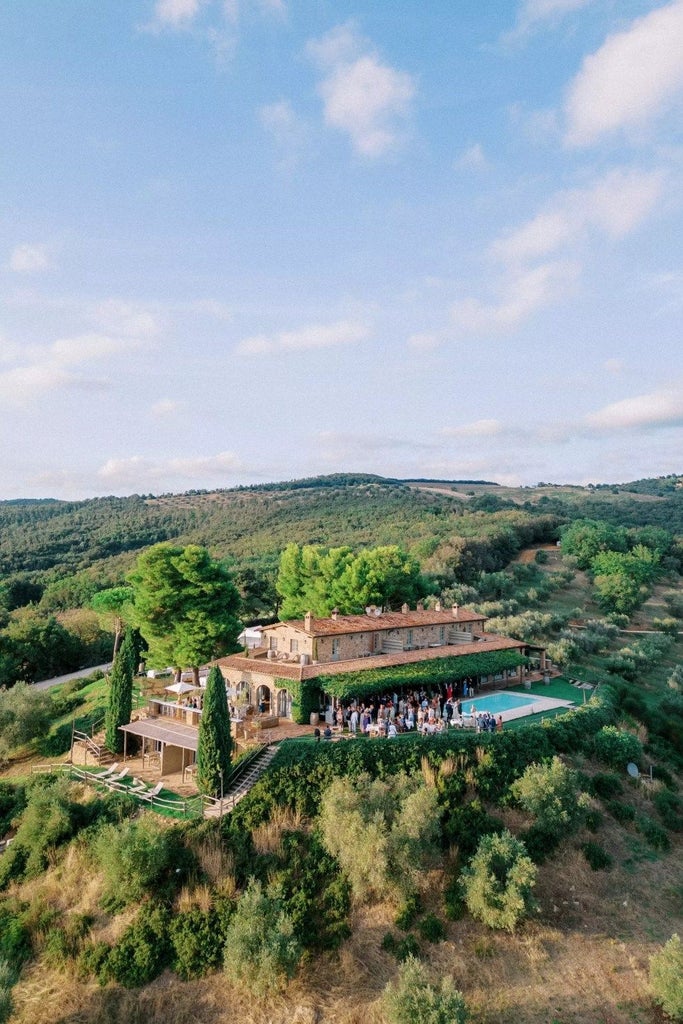 Luxurious Tuscan wine resort nestled among rolling vineyards, with elegant stone buildings, lush gardens, and panoramic countryside views at golden hour