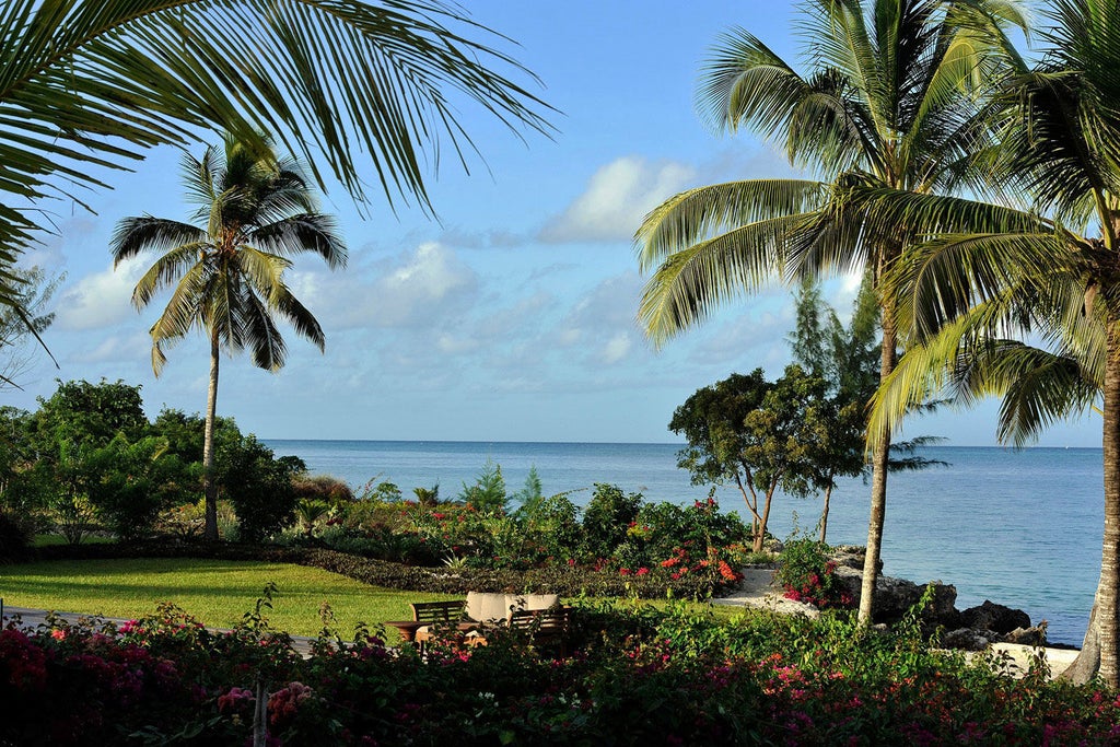 Luxurious oceanfront villa with private infinity pool overlooking pristine beach, surrounded by tropical gardens at The Residence Zanzibar