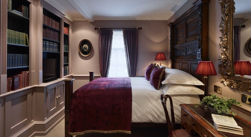 Opulent Georgian-style hotel room with plush navy blue velvet headboard, antique wooden furnishings, and elegant soft lighting at Batty Langley's luxury boutique hotel