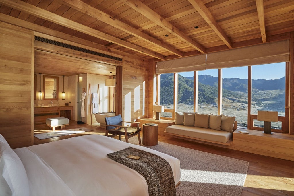 Luxurious lodge suite with panoramic mountain views through floor-to-ceiling windows, featuring modern wood and glass architecture