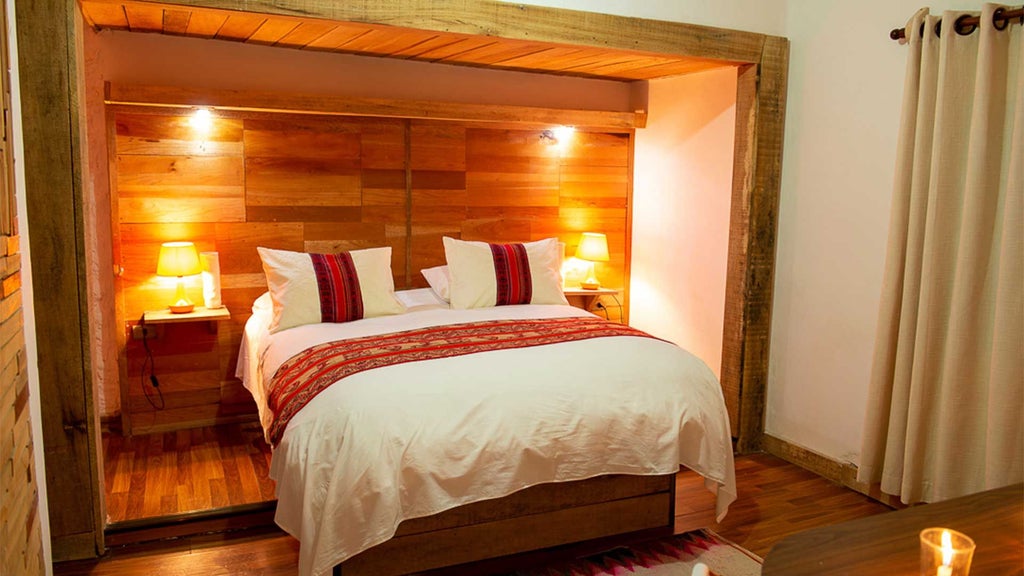 Elegant Bolivian eco-suite with king bed, rustic wooden furnishings, soft natural light, and panoramic mountain view through large window