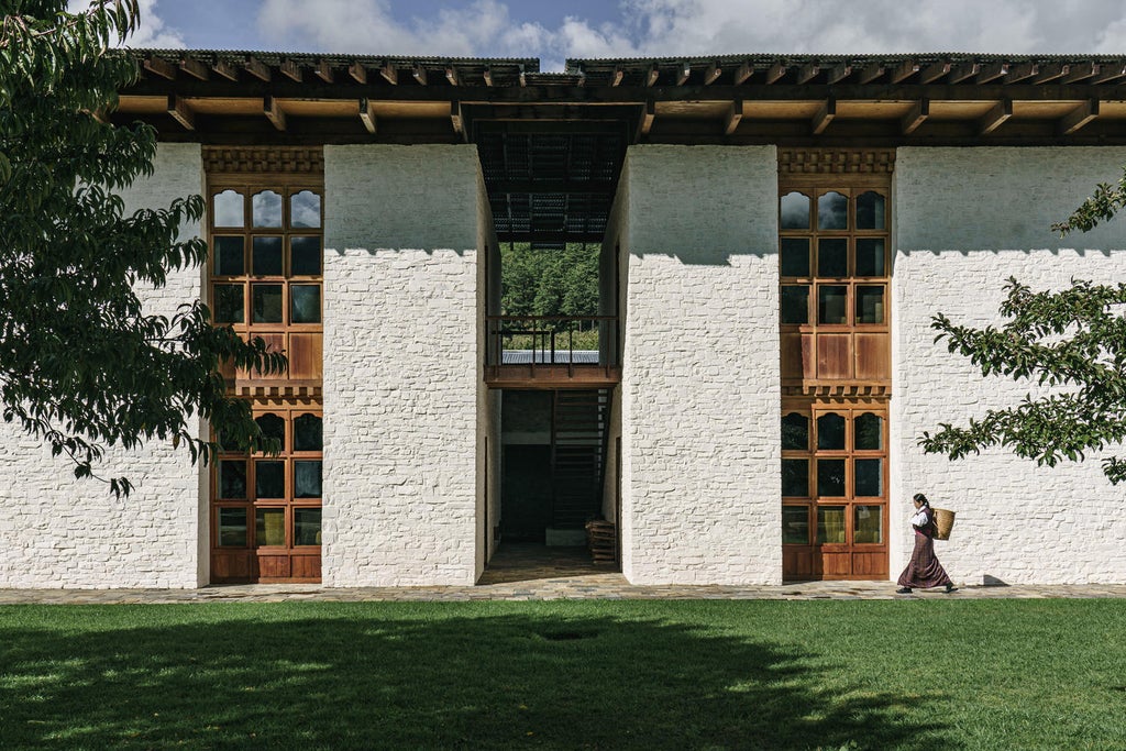 Elegant wooden lodge nestled in Bumthang Valley, featuring traditional Bhutanese architecture with pine forest backdrop and stone courtyard