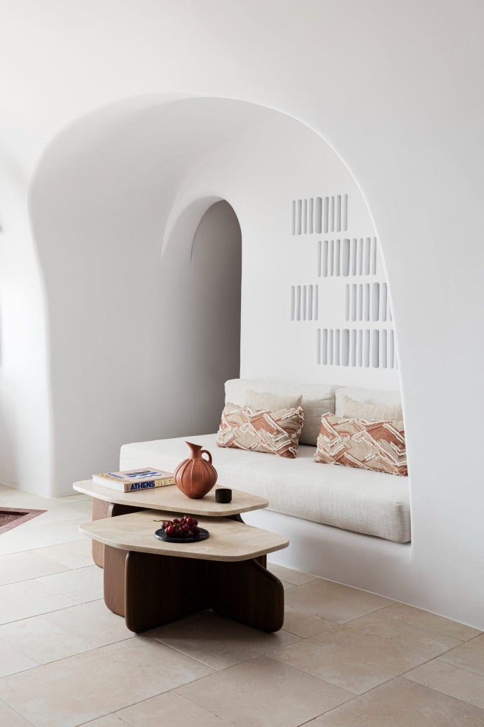 Luxurious senior suite with white-washed walls, minimal design, private plunge pool overlooking Santorini's iconic blue-domed churches and Aegean Sea horizon