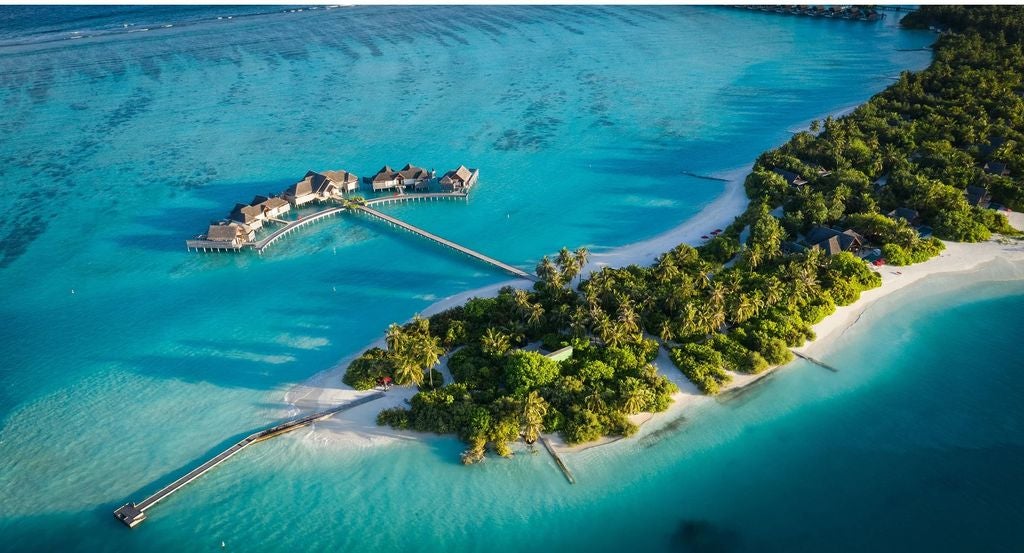 Luxurious overwater villa at Niyama Maldives with private infinity pool, wooden deck and direct ocean access under vibrant blue skies