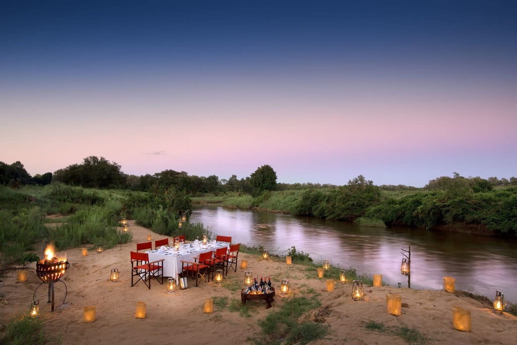 Luxurious safari lodge deck overlooking Sabie River, with private plunge pool, cushioned loungers, and natural wood furnishings