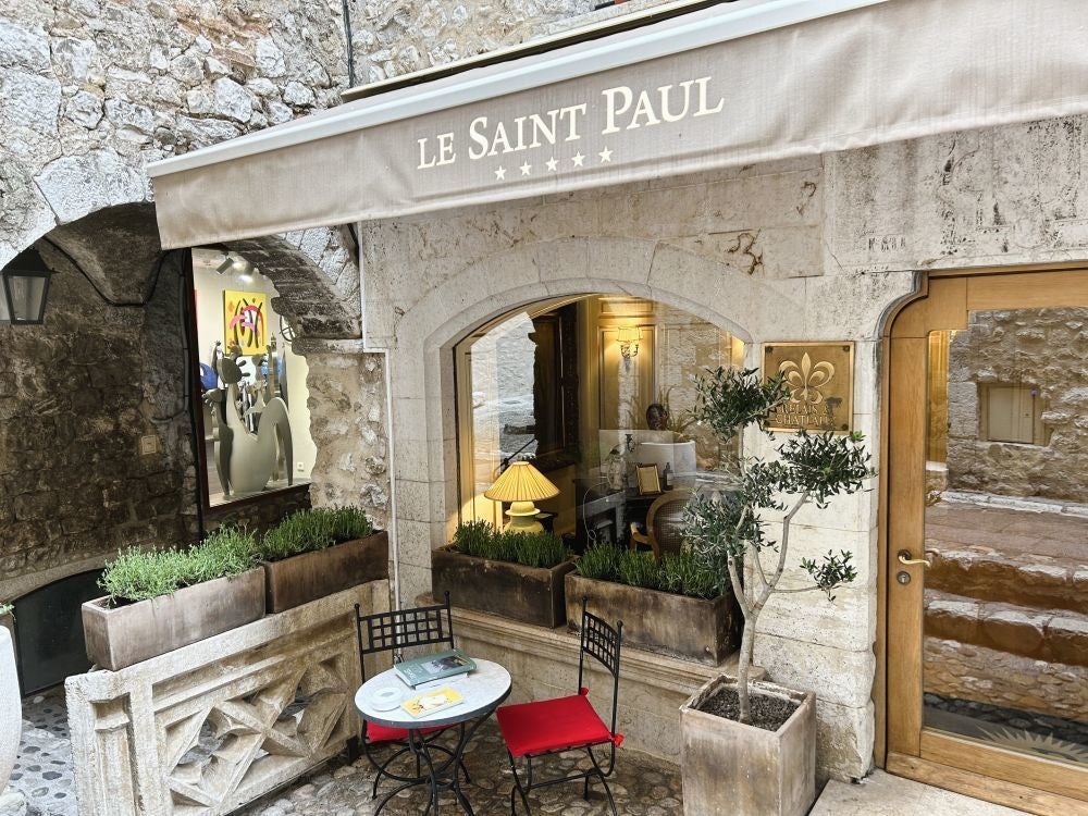 Elegant stone facade of Hotel Le Saint luxury boutique hotel in France, with soft warm lighting, classic architectural details, and charming European streetscape