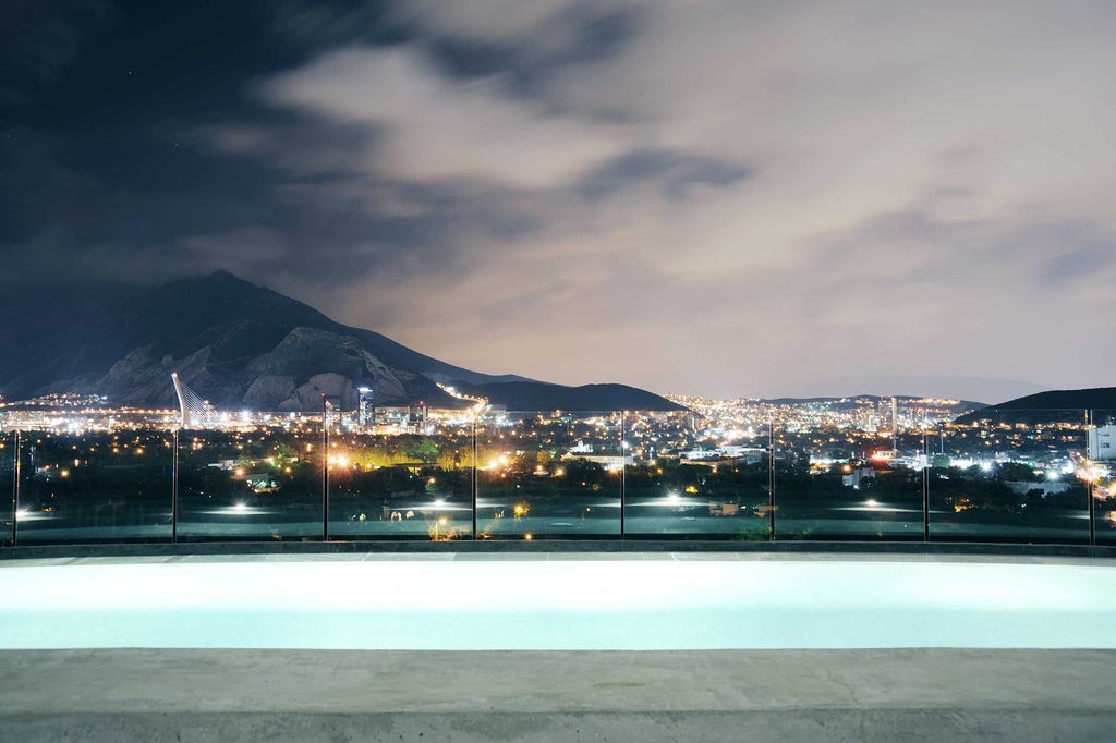 Modern glass and concrete luxury hotel with sleek architectural design, situated in urban landscape of Monterrey, Mexico, showcasing minimalist white facade and contemporary styling