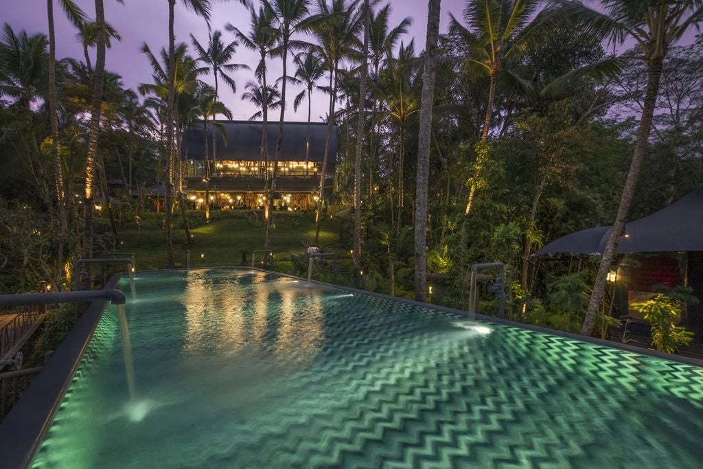 Colonial-style luxury resort Capella Singapore with curved white buildings nestled among lush tropical gardens on Sentosa Island.