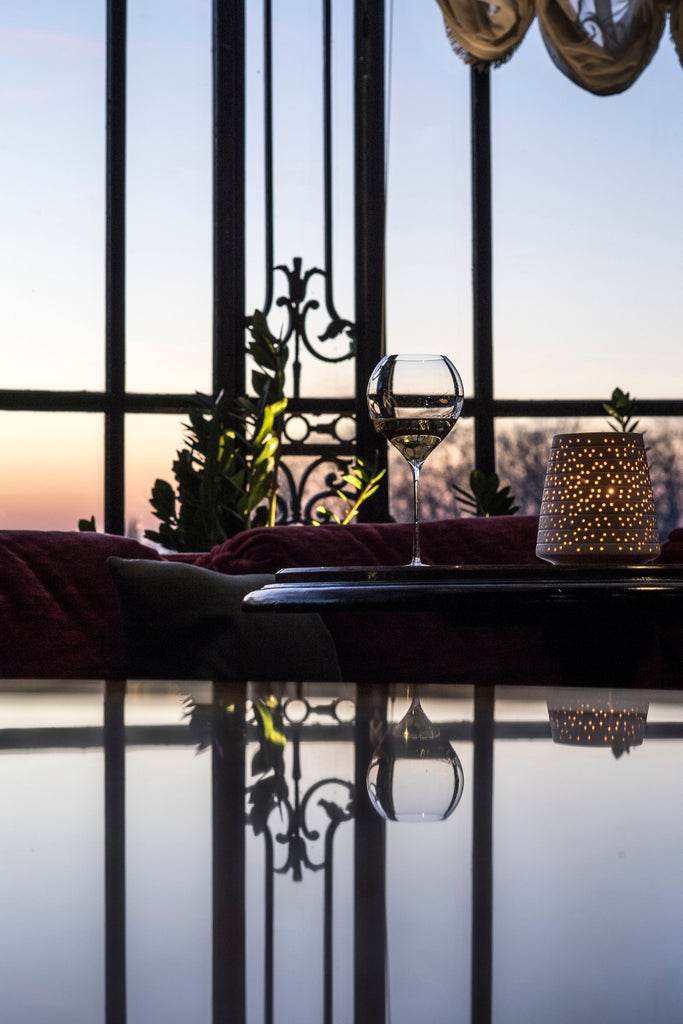 Opulent French chateau hotel with manicured gardens, featuring limestone facade, elegant windows and classic architecture at sunset