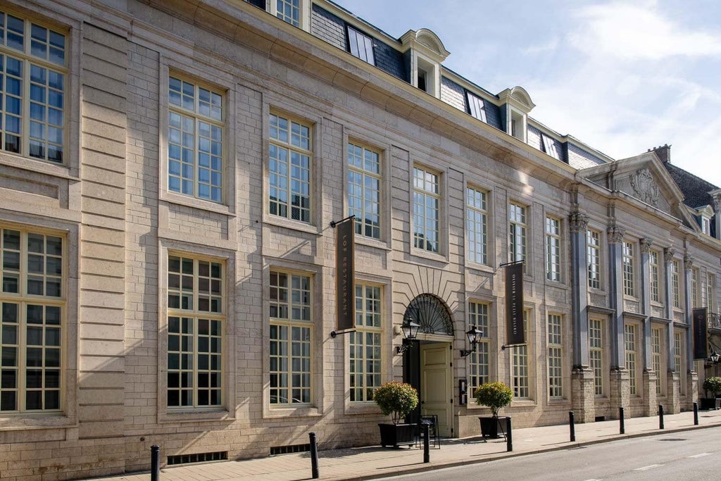 Elegant boutique hotel facade with historic architectural details, ornate windows, and luxurious stone exterior in scenic Belgian urban setting