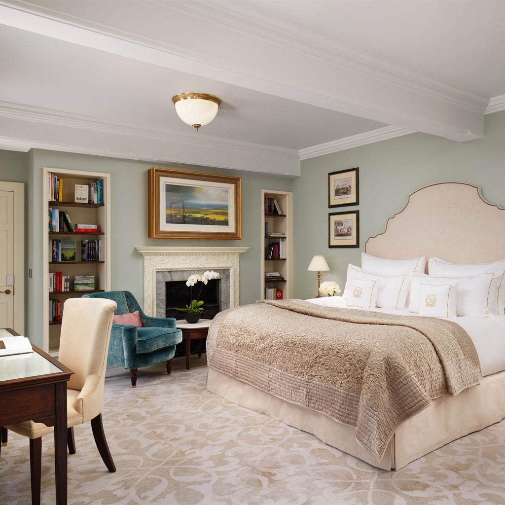 Luxurious junior suite at Grantley Hall with plush king bed, elegant cream furnishings, soft natural lighting, and panoramic view of refined British countryside