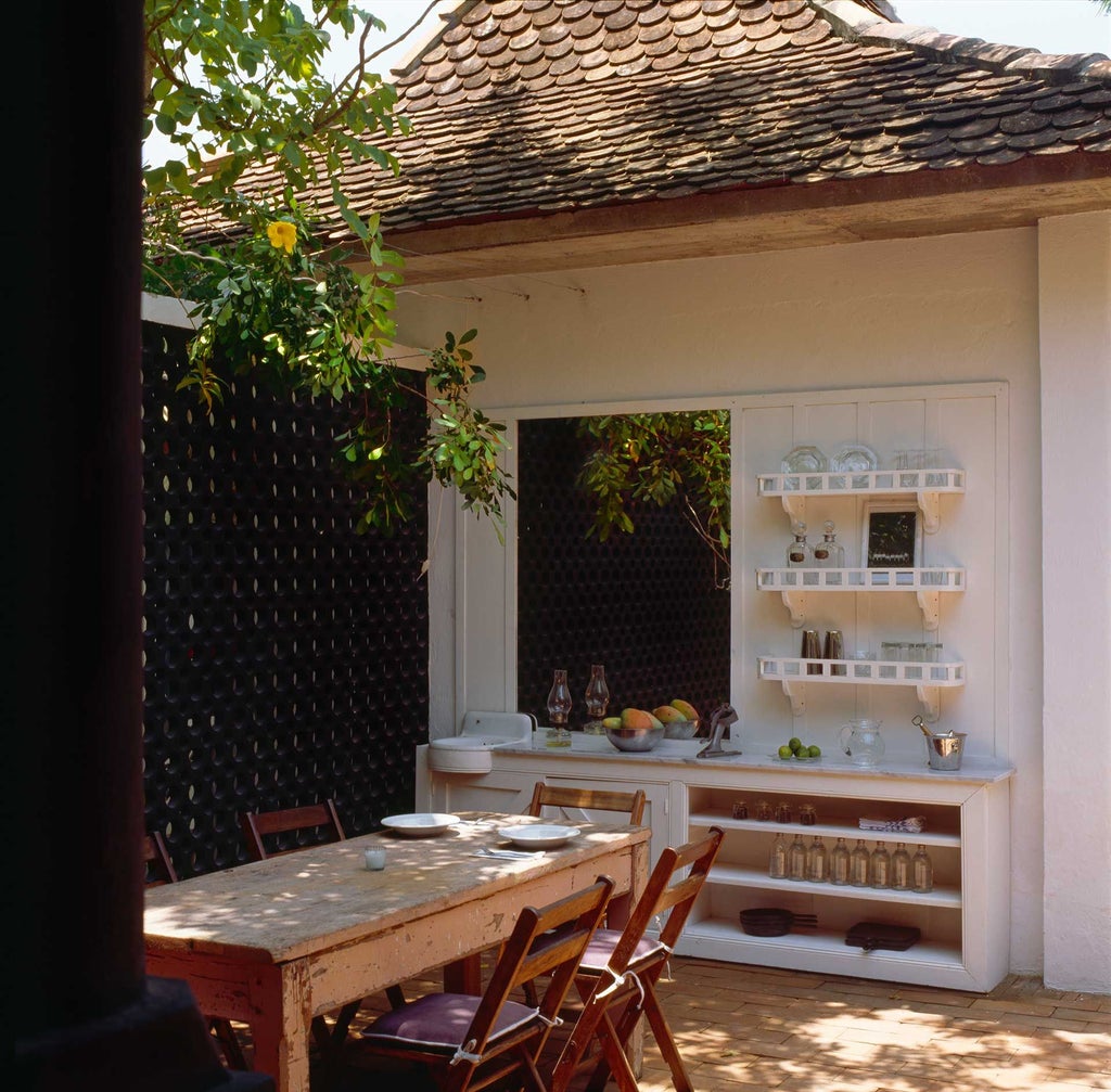 Elegant colonial-style Mexican hotel with lush tropical gardens, vibrant pink walls, and traditional architectural details surrounded by verdant greenery