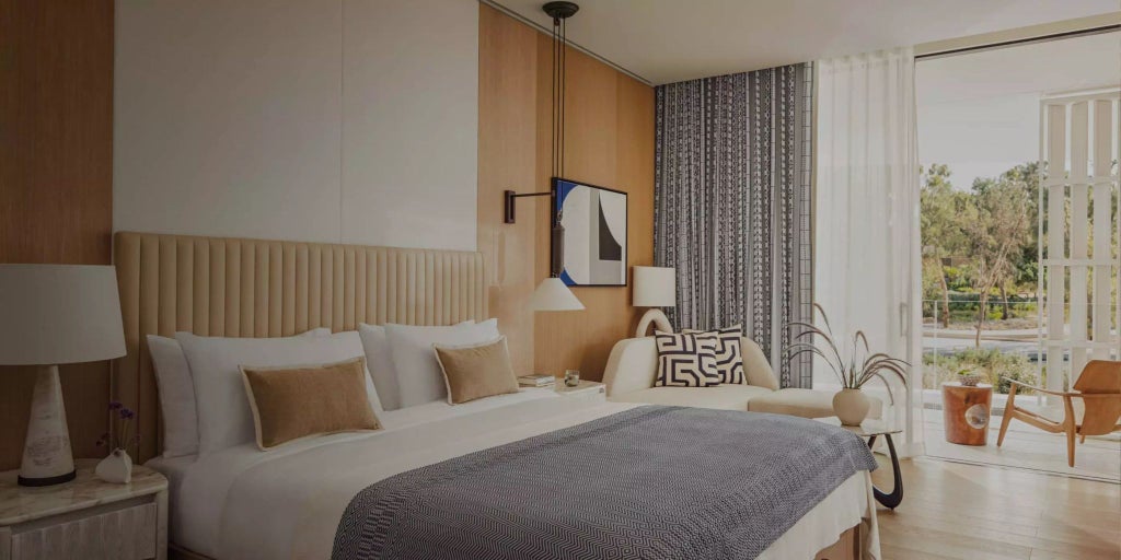 Luxurious minimalist hotel room with white marble floors, expansive sea view, and sleek contemporary furnishings at One&Only Aesthesis in scenic Greece