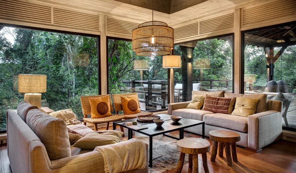 Stilted luxury villa nestled in lush jungle, featuring floor-to-ceiling windows, wooden deck, and private plunge pool at dusk