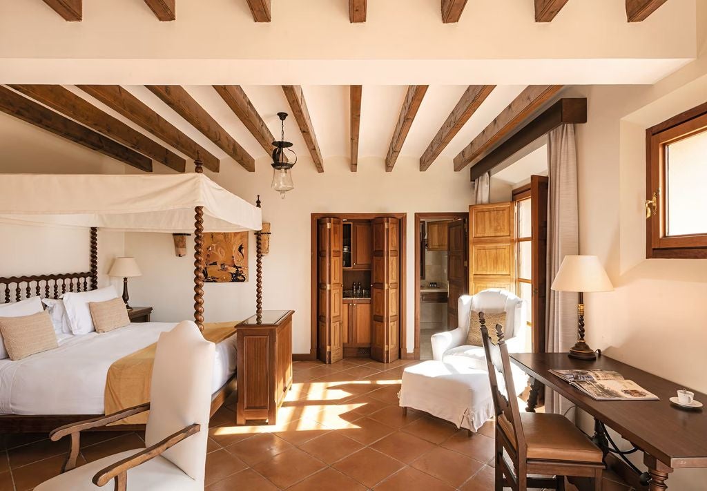 Elegant junior suite with Mediterranean views, featuring terracotta floors, exposed wood beams and luxurious local furnishings