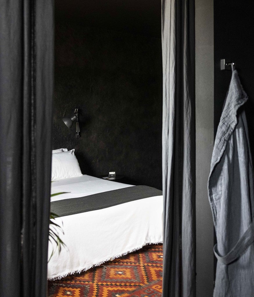 Opulent black-themed luxury suite with minimal design, featuring sleek dark furnishings, polished marble floors, and dramatic contemporary Italian aesthetic