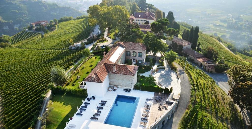 Historic luxury hotel set in Italian countryside with manicured gardens, stone architecture and panoramic views of rolling hills