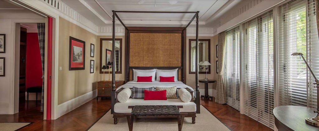 Elegant colonial-style terrace suite with teak floors, vintage furniture, tropical garden views and a private outdoor daybed lounge