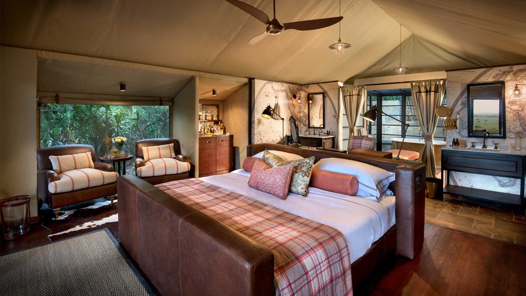 Elegant safari tent with private deck overlooking vast Kenyan savanna at sunset, framed by acacia trees and luxurious outdoor seating