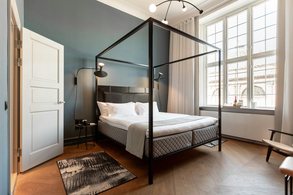 Luxurious deluxe hotel room at Nobis Hotel Copenhagen with modern scandinavian design, elegant furnishings, and soft neutral color palette