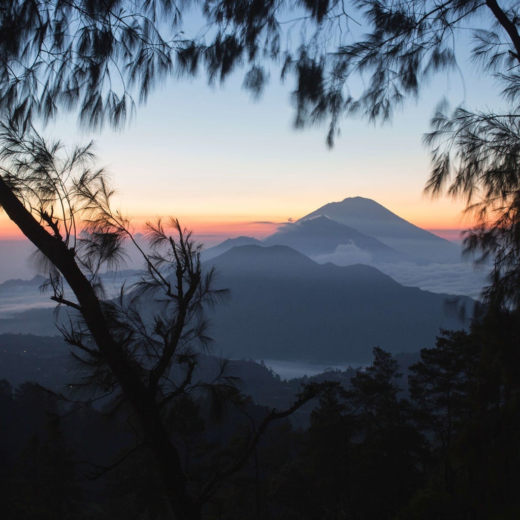 Luxurious COMO Uma Ubud resort nestled in lush Balinese landscape, featuring elegant architecture, tropical vegetation, and infinity pool with mountain views