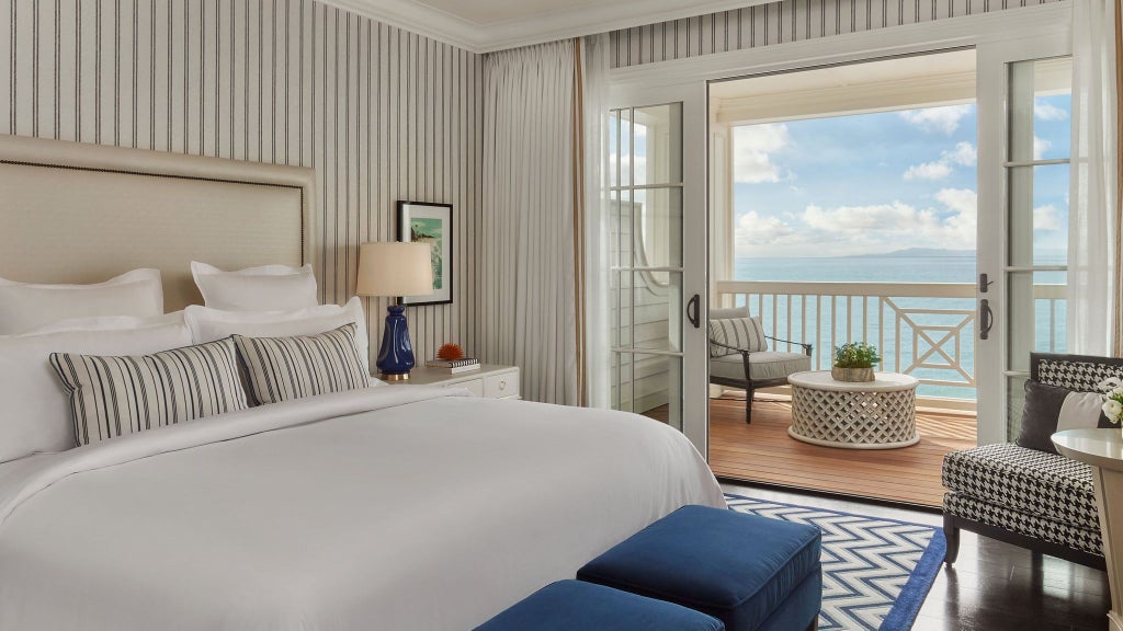 Elegant beachfront terrace suite with panoramic ocean view, plush outdoor seating, and contemporary coastal design at luxury resort