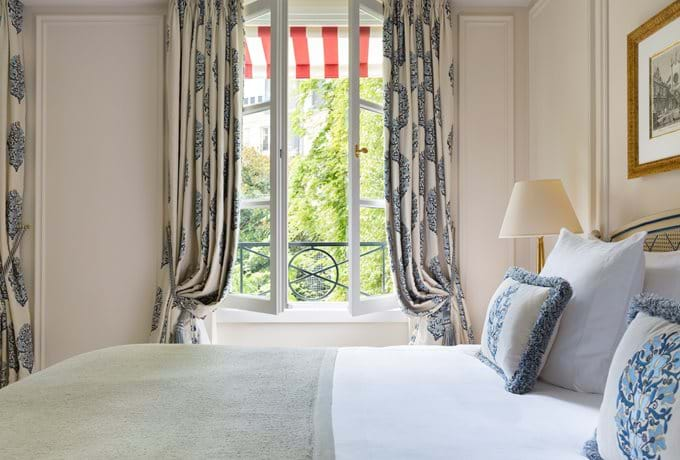 Elegant junior suite with French doors opening to garden views, featuring period furniture, marble bathroom and plush king bed