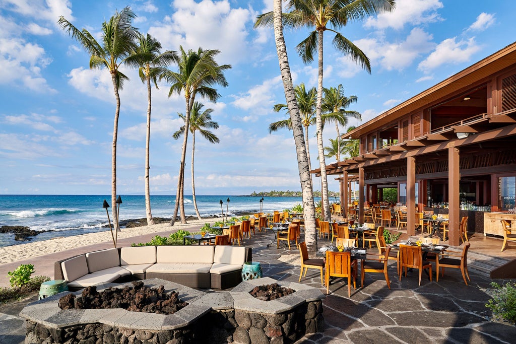 Oceanfront luxury resort with infinity pool overlooking Pacific, surrounded by tropical gardens and volcanic rock formations