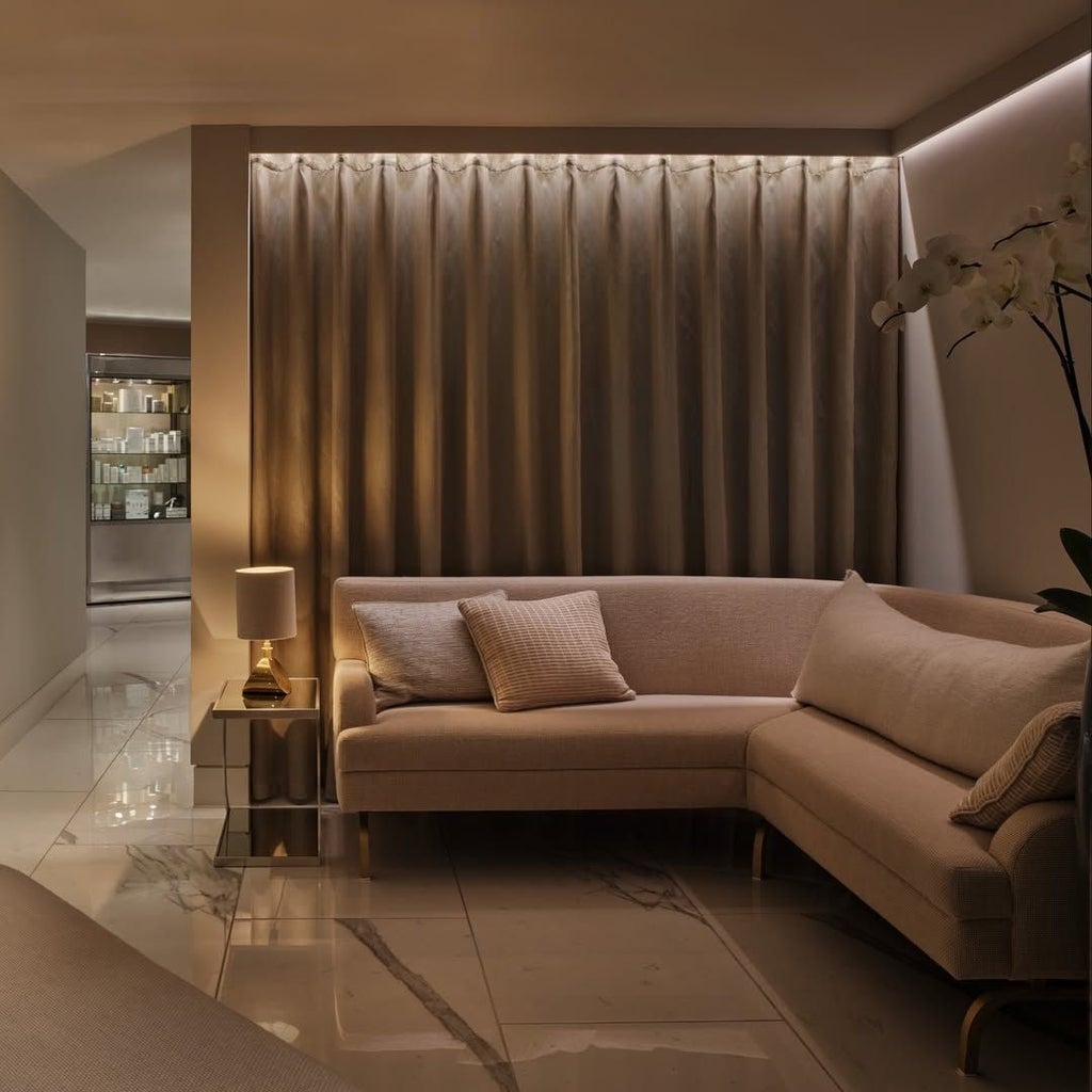 Elegant marble-clad bathroom with freestanding soaking tub, city skyline view, plush towels, and sophisticated modern design at luxury UK hotel